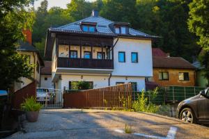 a large white house with a fence in front of it at Riverside Residence Apartment in Travnik