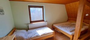 a small room with two beds and a window at Apartmány Na Lontě in Cotkytle