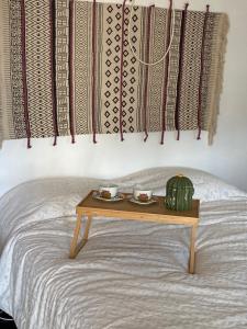 a table with two cups and a cactus on a bed at Pinzalez 