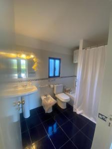 a bathroom with a toilet and a sink and a tub and a toilet at Pinzalez 