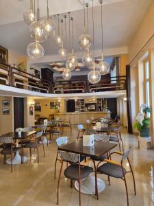 a restaurant with tables and chairs and chandeliers at Hôtel Saint Sébastien in Lourdes