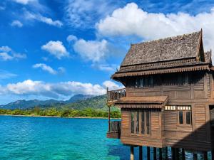 a wooden building on a dock in the water at Langkawi Lagoon Floating Resort 03 in Kampung Padang Masirat