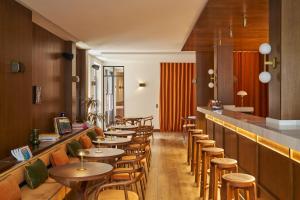 a row of tables and chairs in a restaurant at Latroupe Hotel Jardin Secret in Brussels