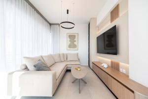 a living room with a couch and a tv at Sofia's Estates - Villa Athena -Adults Only- in Kos