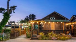 a log cabin with lights on the front of it at boryeong hiddenvillage dokchae poolvilla in Boryeong