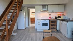 a kitchen with a white refrigerator and a staircase at Laure Cabasson in Bormes-les-Mimosas +5 photos