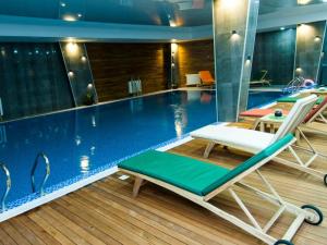 a swimming pool with chairs and a pool at Apartment Mountain Orchid in Gudauri