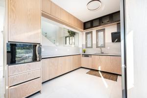 a kitchen with wooden cabinets and a sink at Sofia's Estates - Villa Athena -Adults Only- in Kos