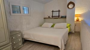 a bedroom with a bed with two pillows and a mirror at Laure Cabasson in Bormes-les-Mimosas