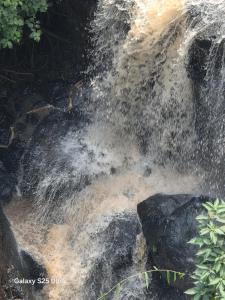 a stream of water coming out of a waterfall at Kitusiru Falls Retreat, in Kanyongo