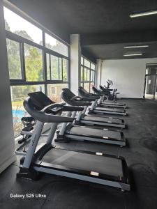 a row of treadmills in a gym with windows at Kitusiru Falls Retreat, in Kanyongo +4 photos