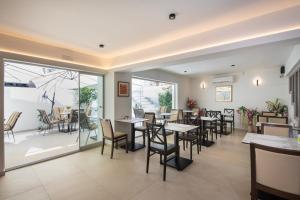ein Restaurant mit Tischen und Stühlen und einer Terrasse in der Unterkunft Leonidas Hotel & Apartments in Rethymno