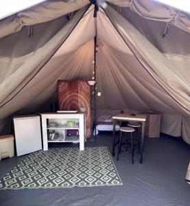 a room with a tent with a table and a desk at Tente lodge in Brassac