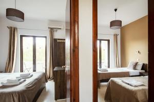 a hotel room with two beds and a window at Mariposa Apartments in Kavos