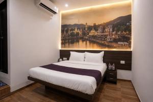 a bedroom with a bed with a painting on the wall at Hotel Dwarka Executive in Nashik