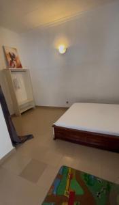 a bedroom with a bed and a rug on the floor at Bk House in Pointe-Noire