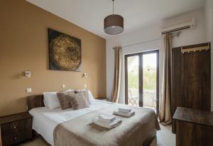a bedroom with a large bed with towels on it at Mariposa Apartments in Kavos