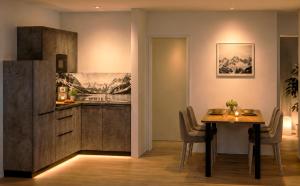 a kitchen and dining room with a table and a refrigerator at Das Apartment Rief daheim beim Wanderprofi Adults Only in Tannheim