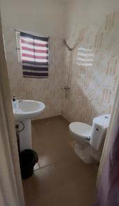 a bathroom with a toilet and a sink at Bk House in Pointe-Noire