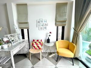a living room with a yellow chair and a table at Milky house in Ban Bang Phai