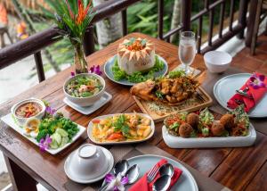 a wooden table with plates of food on it at River Kwai Resotel in Sai Yok