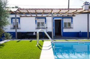 a swimming pool in front of a house with a house at O Rossio in Esperança