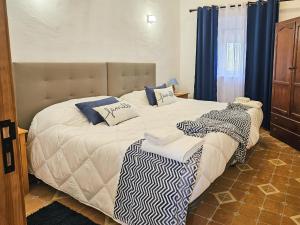 two twin beds in a bedroom with blue curtains at O Rossio in Esperança