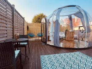a gazebo on a deck with a table and chairs at Reves2bulles in Ousse