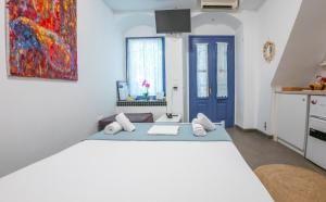 a bedroom with a large bed with a painting on the wall at Kali Strata 1 - Downtown in Symi