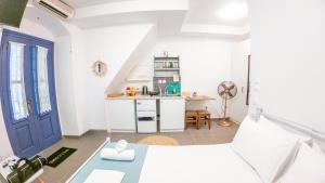 a kitchen with white walls and a blue door at Kali Strata 1 - Downtown in Symi