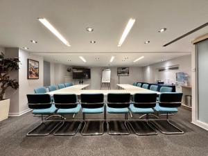 a conference room with a long table and blue chairs at Mercure London Paddington Hotel in London