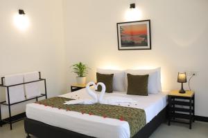 two white swans sitting on a bed in a room at Ayurya Wellness Retreat in Kandy +30 photos