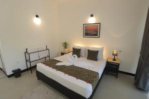 a bedroom with a bed with two swans on it at Ayurya Wellness Retreat in Kandy