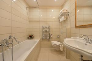 y baño con bañera, aseo y lavamanos. en Hotel Hastal Prague Old Town en Praga