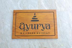 a wooden sign for a wellness retreat with a ziggurat at Ayurya Wellness Retreat in Kandy