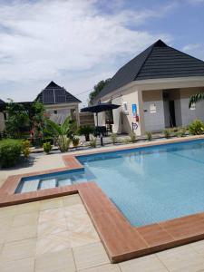 a swimming pool in front of a house at Stallion Luxury Suites Mararaba in Abuja