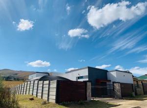a building with a fence and a blue sky at Siwela in Darkton