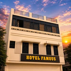 a building with a hotelfamous sign in front of a sunset at Hotel Famous in Haridwār