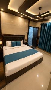 a bedroom with a large bed with blue sheets at Hotel Famous in Haridwār