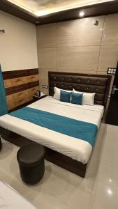 a bedroom with a large bed with blue pillows at Hotel Famous in Haridwār