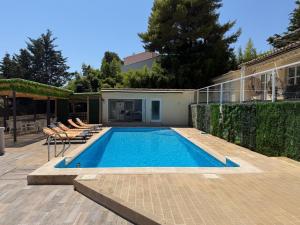 a swimming pool with chairs and a house at Villa avec piscine à Super Cannes in Vallauris
