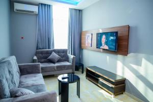 a living room with a couch and a table at Exclusive Serene Hotel Abuja in Abuja