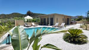 a swimming pool with chairs and a house at Villa Emanouill Nopigia in Kissamos