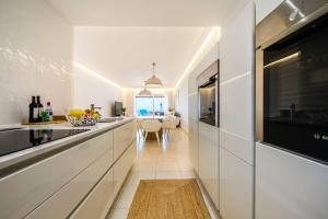 a kitchen with white walls and a long counter at Villa Afreen Playa in Morro del Jable
