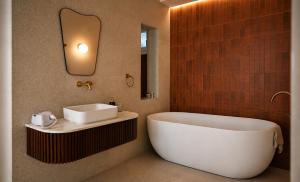 a bathroom with a white tub and a sink at Old Town Boutique Suites in Lefkada