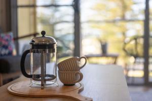a tea kettle and a cup sitting on a table at Seaspray Views - Lifestyle Yamba in Yamba