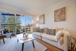 a living room with a couch and a table at Seaspray Views - Lifestyle Yamba in Yamba