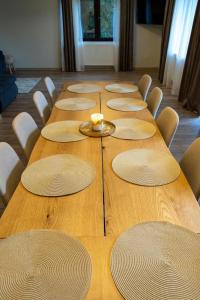 a long wooden table with chairs and a candle on it at Vila dintre Brazi in Râu de Mori