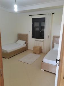 two beds in a room with a window at Villa Lila in Cherchell +12 photos