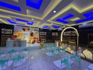 a banquet hall with white chairs and a dance floor at Odyssey Rendezvous in Chottanikara